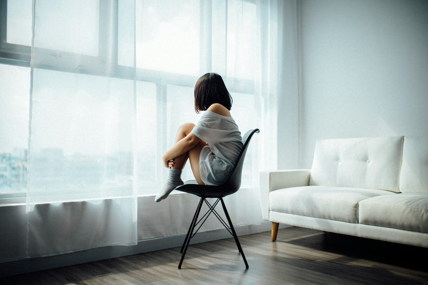 Mujer sentada mirando por la ventana