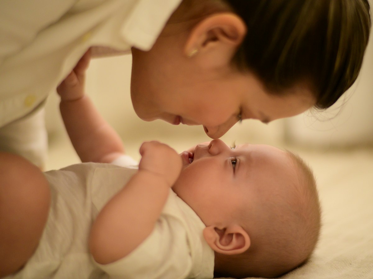 Mamá sonriendo con su bebé en brazos