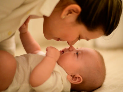 Mamá sonriendo con su bebé en brazos