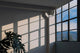Luz del sol entrando por una ventana sobre una pared blanca