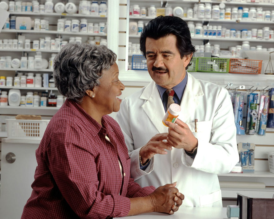 Farmacéutico asesorando a una paciente en la droguería