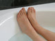 Pies descansando en una bañera blanca