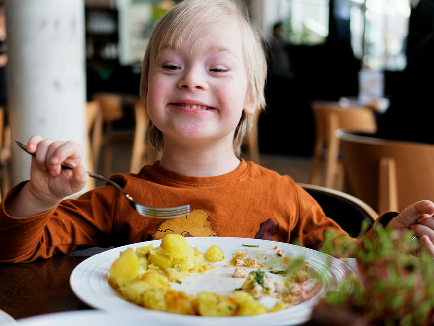 Niño sonriente comiendo en la mesa
