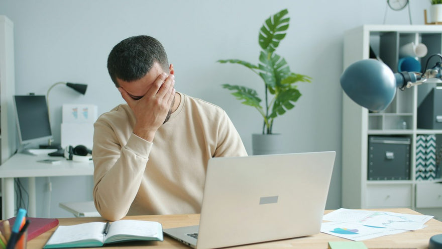 Persona con dolor de cabeza frente al computador