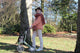 Adulta mayor caminando en un parque con su caminador